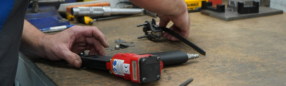 man repairing a pneumatic air tool