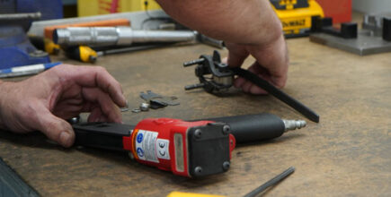 man repairing a pneumatic air tool