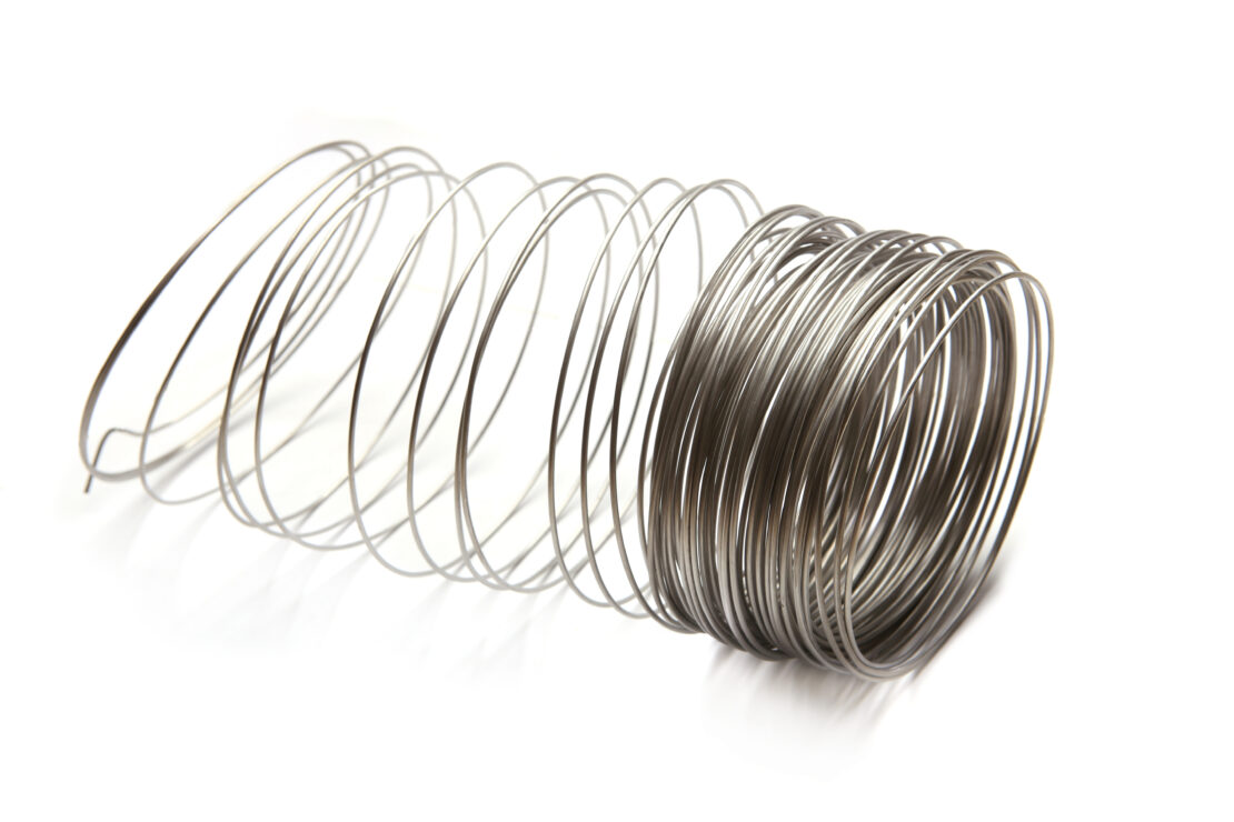 A stainless steel wire form in the shape of a coil on a white background