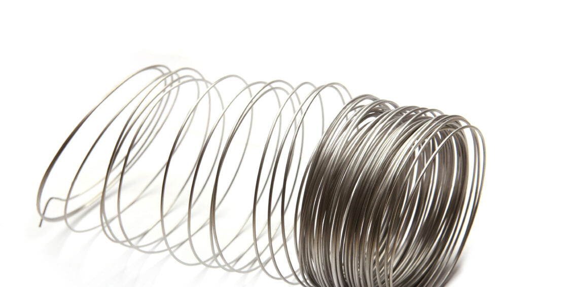 A stainless steel wire form in the shape of a coil on a white background